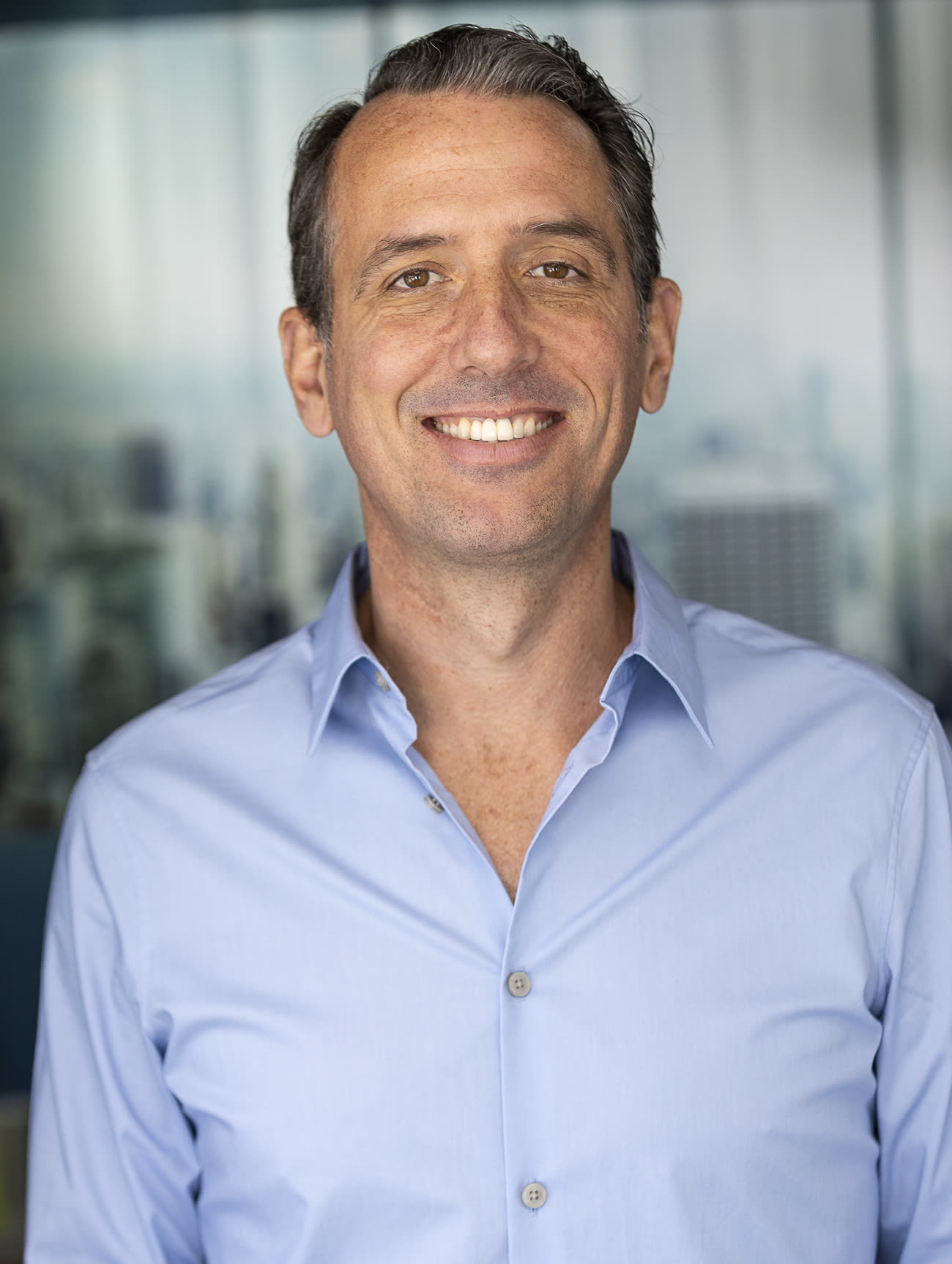 Mark Quann, founder of The Perfect Portfolio, smiling in a blue shirt